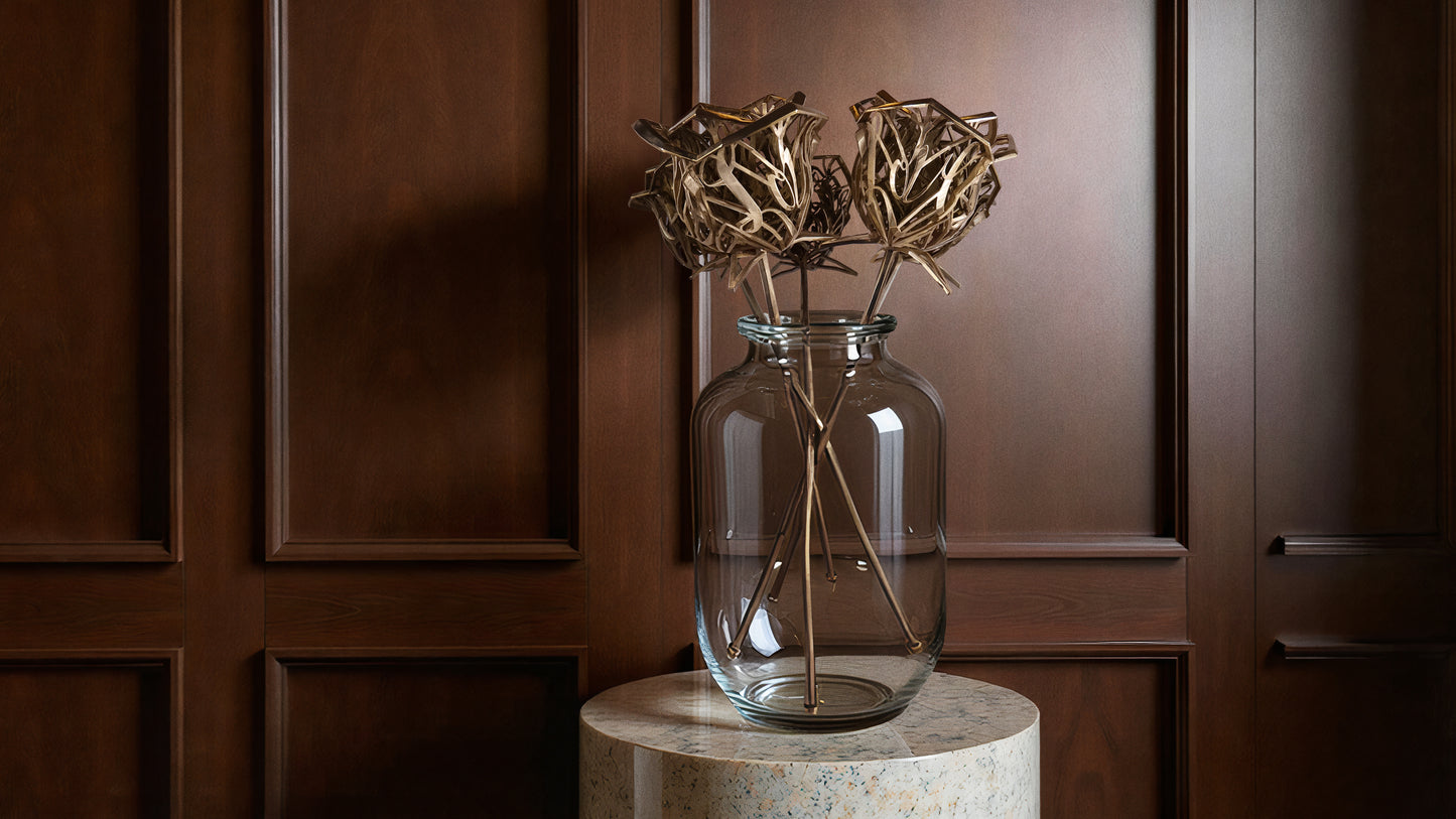 Fine-art bronze rose sculptures displayed in a clear vase on a stone pedestal, luxury interior with wood panel backdrop